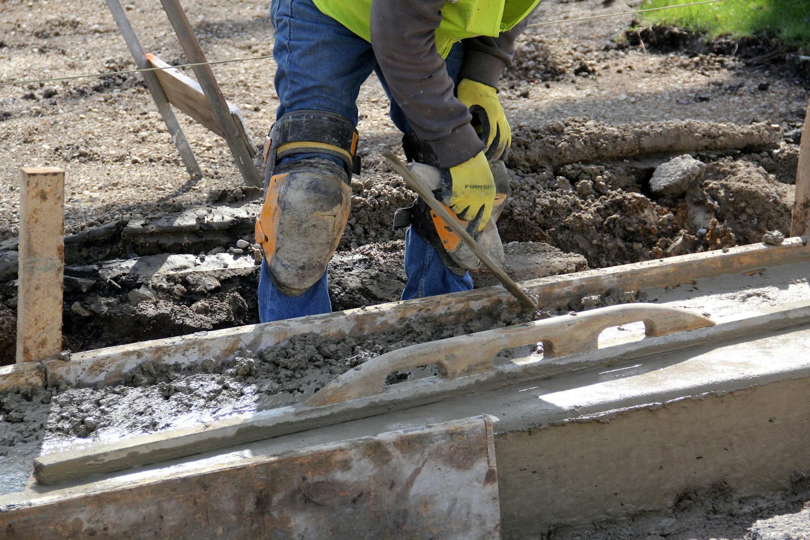 Worker finishing concrete with hand tools